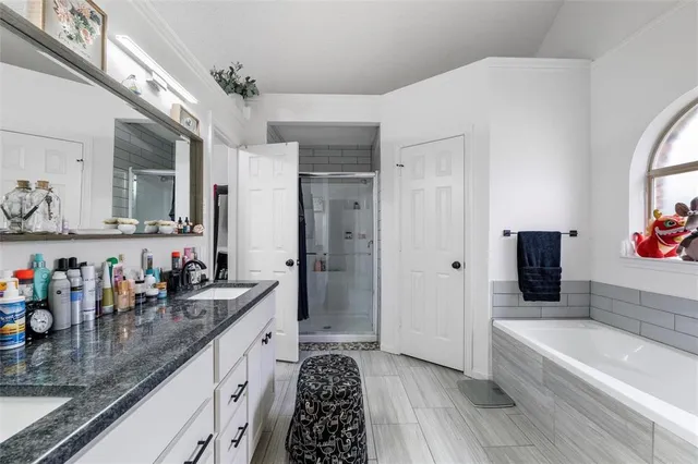 a large bathroom with a double vanity sink a mirror and a bathtub