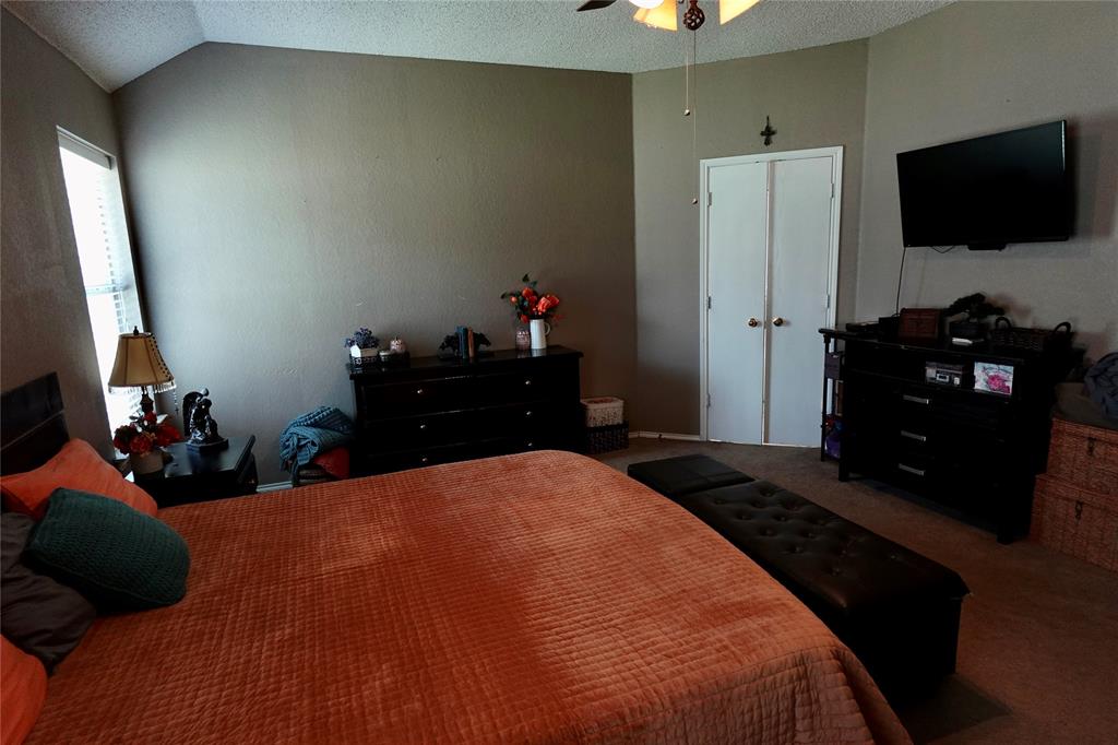 173 West Ranch Lane Weatherford, TX 76088 - Photo 12 of 29 a bedroom with a bed and a flat tv screen on dresser