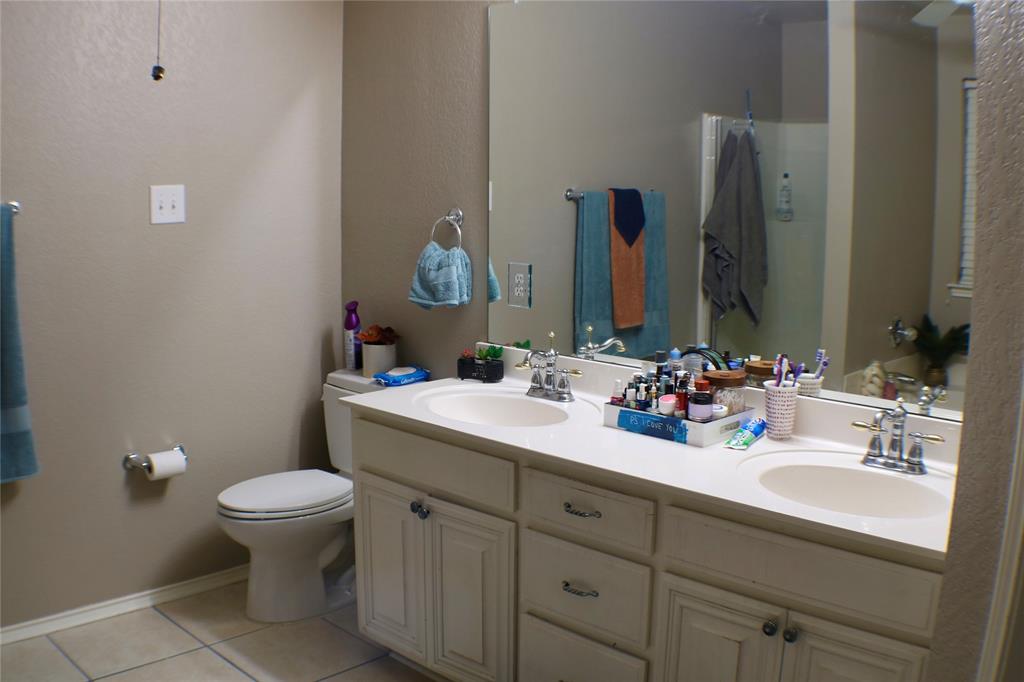 173 West Ranch Lane Weatherford, TX 76088 - Photo 14 of 29 a bathroom with a double vanity sink toilet and a mirror