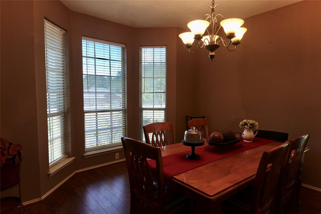 173 West Ranch Lane Weatherford, TX 76088 - Photo 4 of 29 a dining room with furniture a chandelier and wooden floor