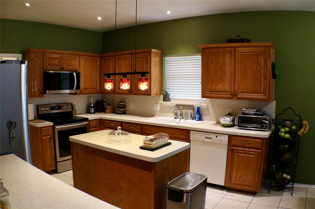 173 West Ranch Lane Weatherford, TX 76088 - Photo 6 of 29 a kitchen with a sink a stove and a microwave