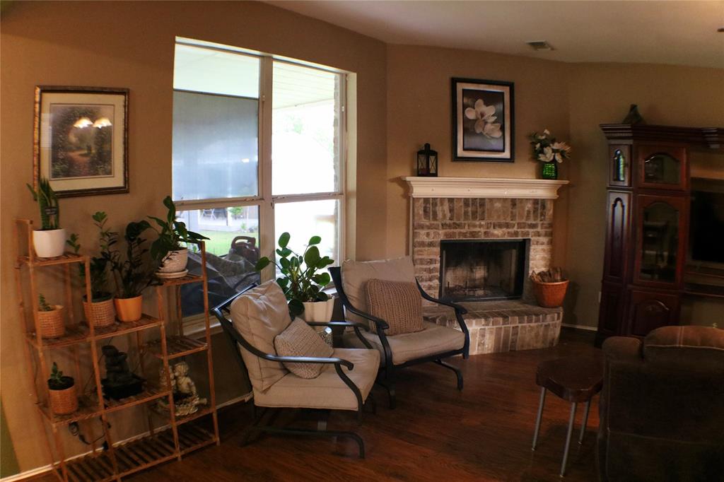 173 West Ranch Lane Weatherford, TX 76088 - Photo 9 of 29 a living room with furniture a large window and a fireplace