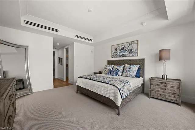 a spacious bedroom with a bed and a cabinets
