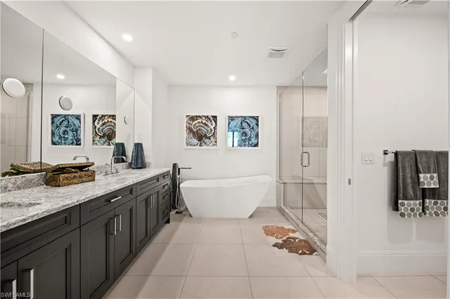 a bathroom with a granite countertop sink a toilet a mirror and shower