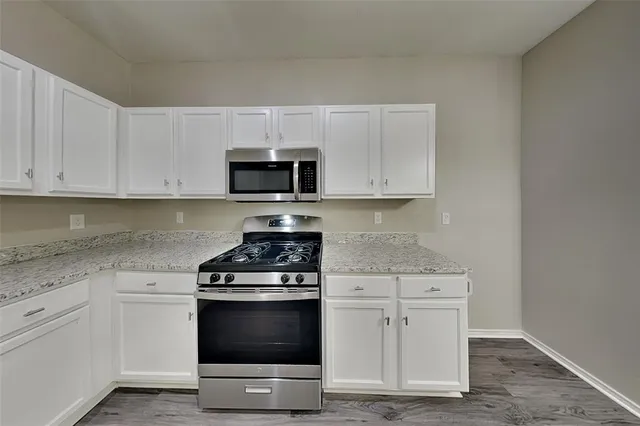 a kitchen with white cabinets and appliances