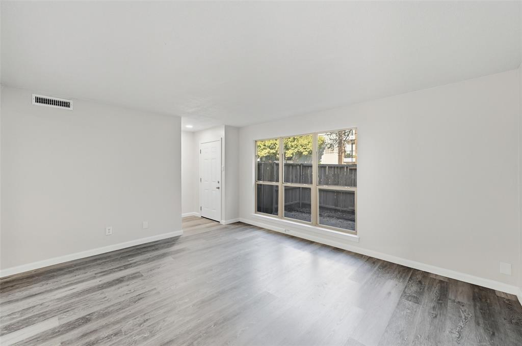 2702 Douglas Avenue, Unit 121 Dallas, TX 75219 - Photo 9 of 34 an empty room with wooden floor and windows
