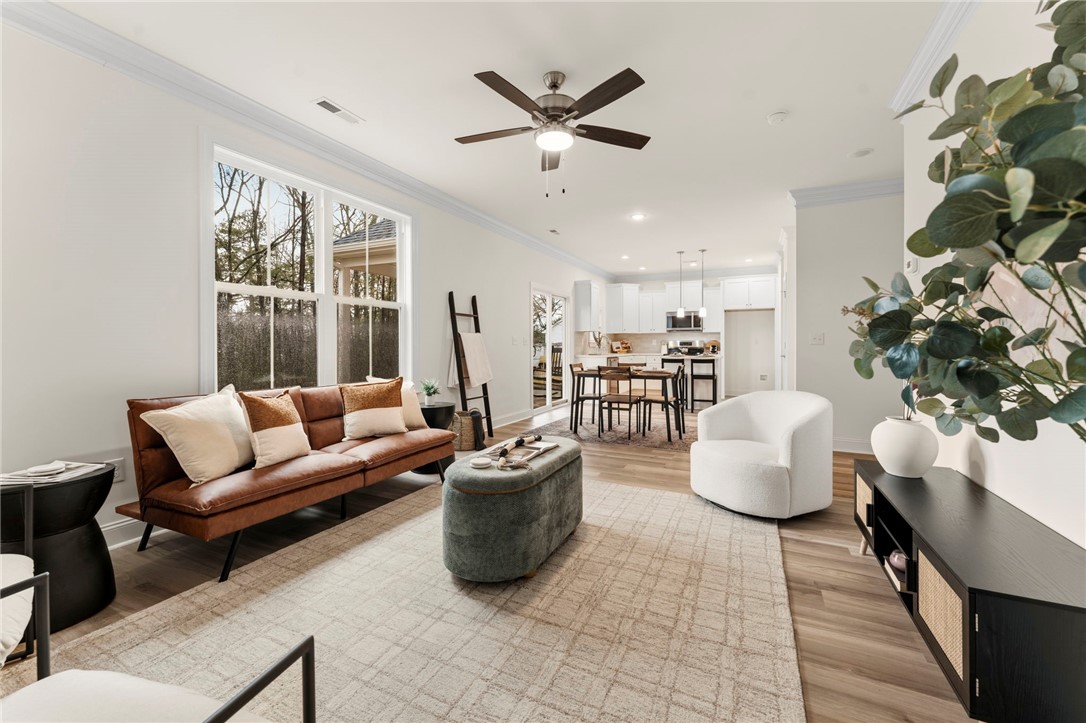 505 Fire Tower Road Williamston, SC 29697 - Photo 9 of 37 This bright open-concept living space features expansive windows and hardwood floors, seamlessly connecting to the modern kitchen.