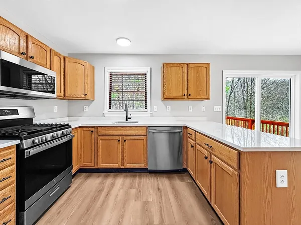 a kitchen with stainless steel appliances granite countertop a stove a sink and a microwave