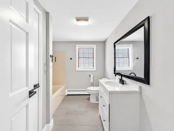 a bathroom with 2 sink toilet and a mirror