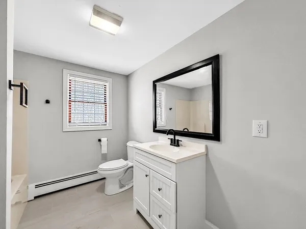 a bathroom with a toilet sink and mirror