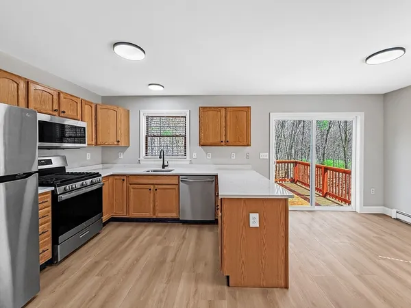 a kitchen with stainless steel appliances granite countertop a stove a sink dishwasher a refrigerator and a oven with wooden floor