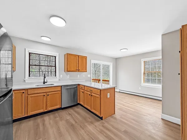 a large kitchen with stainless steel appliances granite countertop a sink and cabinets with wooden floor