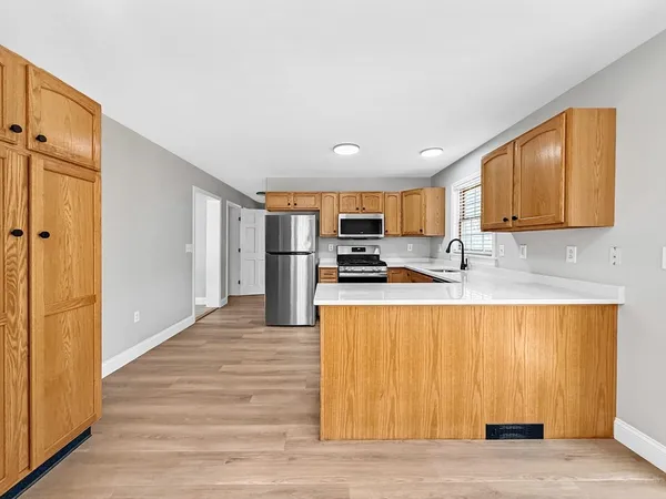 a large kitchen with stainless steel appliances granite countertop a refrigerator and a stove top oven