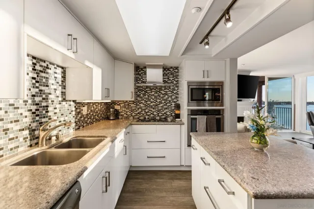 a living room with furniture a flat screen tv and kitchen view