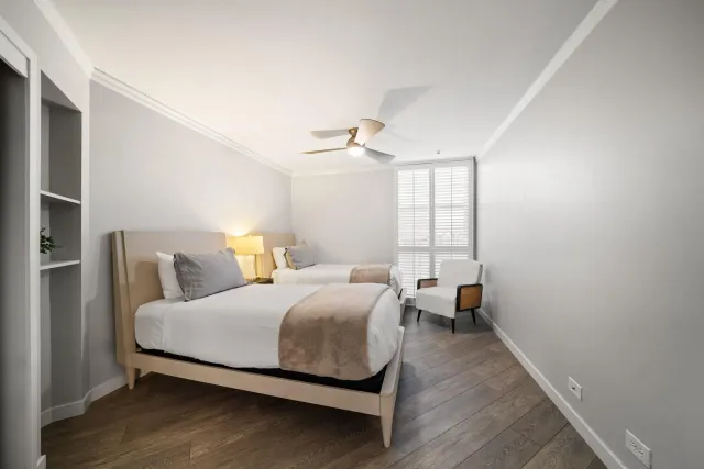 a bedroom with two beds and painting on the wall