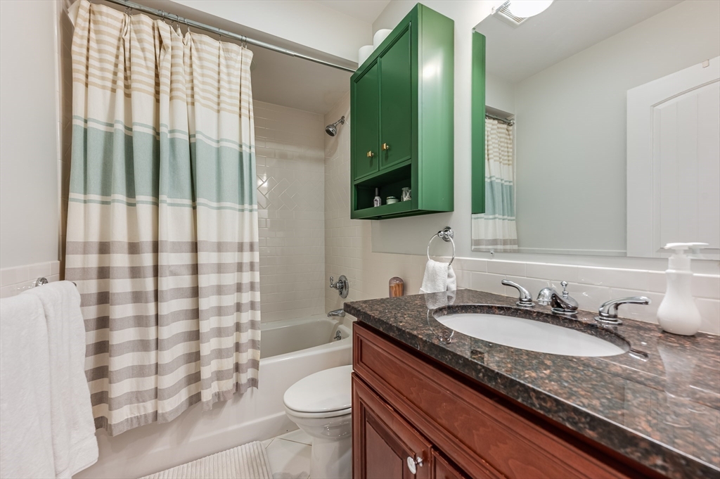 46 Rutherford Avenue Boston, MA 02129 - Photo 20 of 33 a bathroom with a granite countertop sink and a mirror
