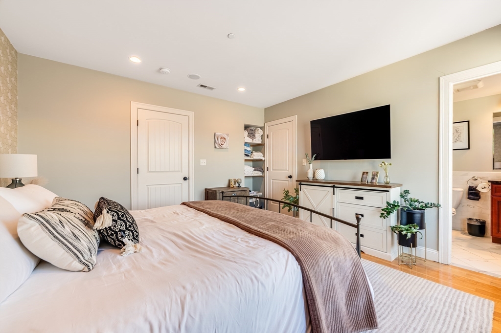 46 Rutherford Avenue Boston, MA 02129 - Photo 22 of 33 a bedroom with a bed and a flat tv screen on wall