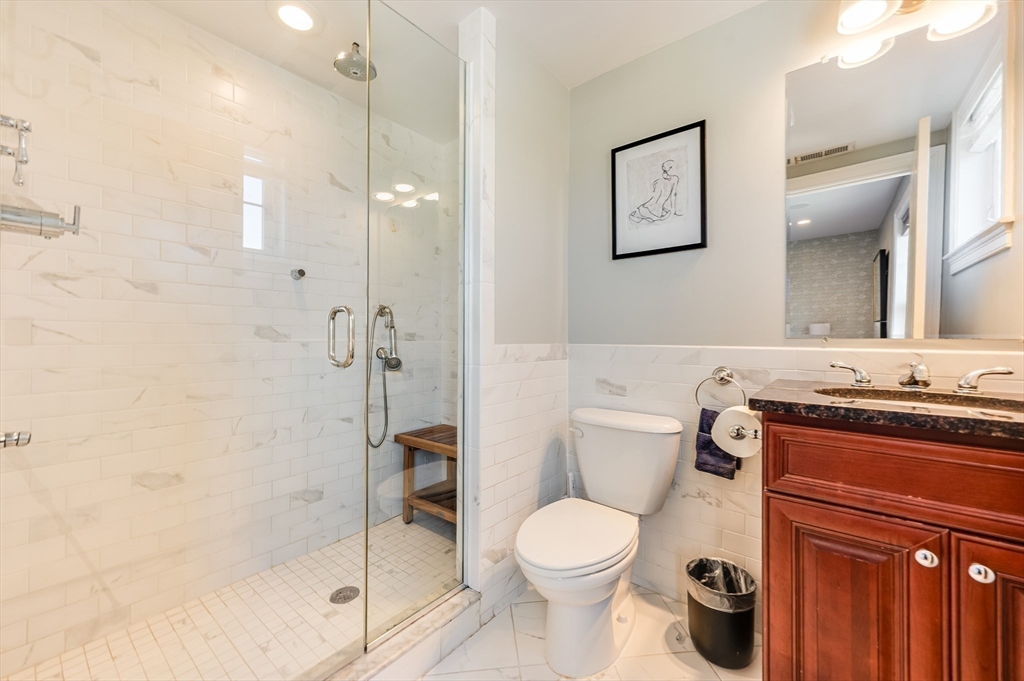 46 Rutherford Avenue Boston, MA 02129 - Photo 23 of 33 a bathroom with a granite countertop toilet a sink and a shower