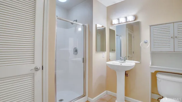 a bathroom with a sink a toilet and shower