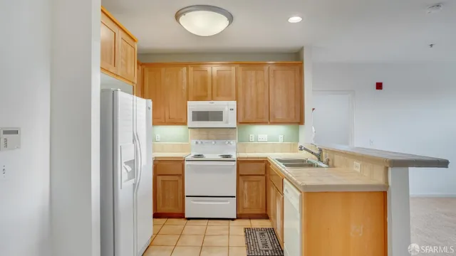 a kitchen with a sink a refrigerator and cabinets