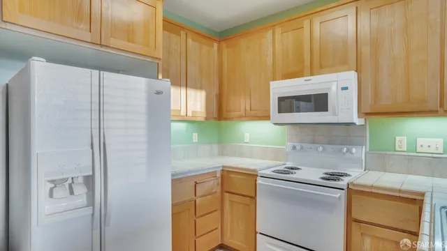 a kitchen with stainless steel appliances granite countertop white cabinets and a refrigerator