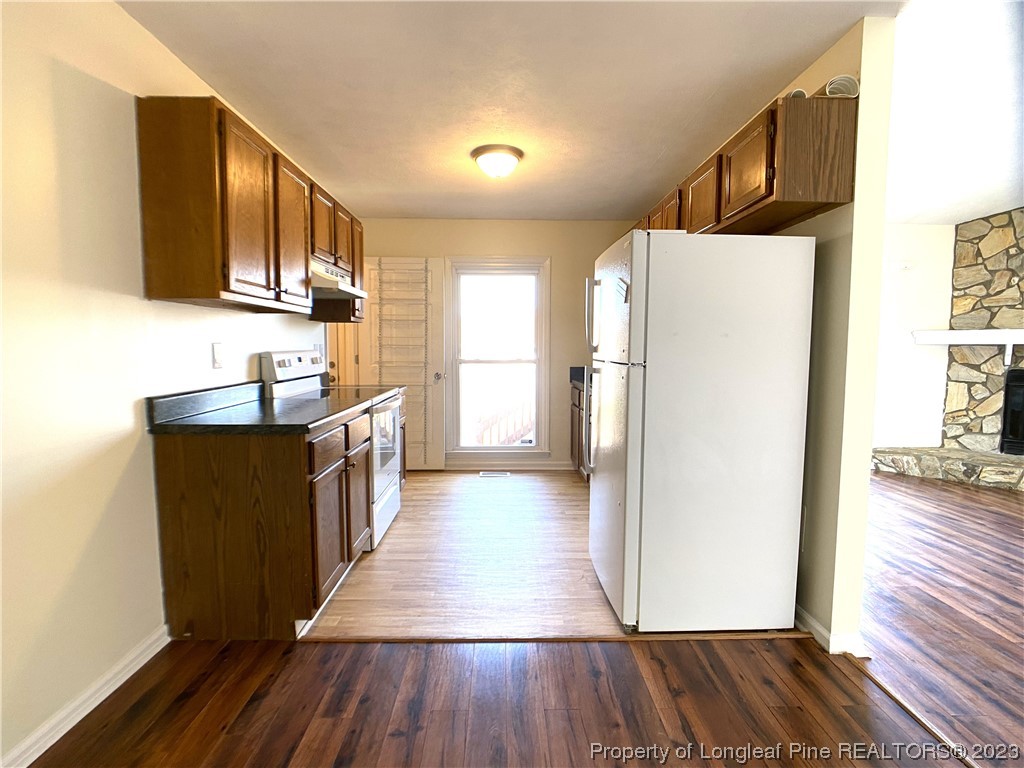 5686 Castleton Drive Hope Mills, NC 28348 - Photo 6 of 21 a kitchen with granite countertop wooden floors a sink and appliances