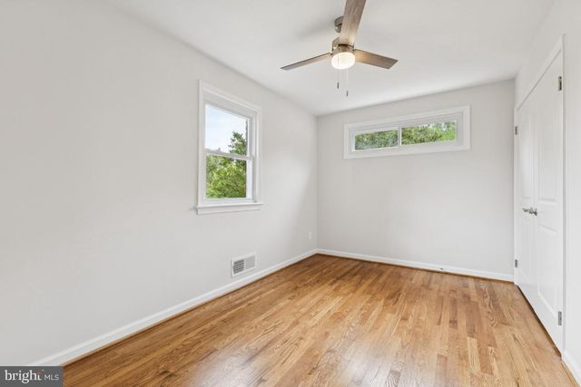 an empty room with a window and ceiling fan