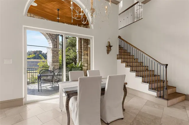 a dining room with furniture water view and a floor to ceiling window