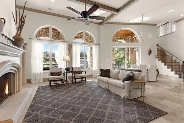 a living room with furniture a fireplace and a chandelier