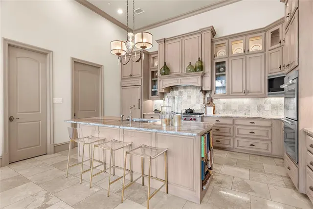 a kitchen with cabinets and chairs