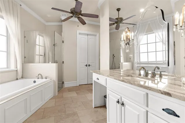 a bathroom with a granite countertop sink a mirror a bathtub and shower