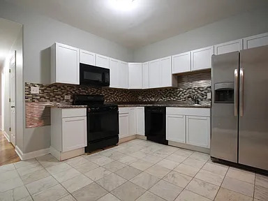 1922 West 47th Street, Unit 2 Chicago, IL 60609 - Photo 19 of 20 a kitchen with stainless steel appliances granite countertop a stove a sink and a refrigerator