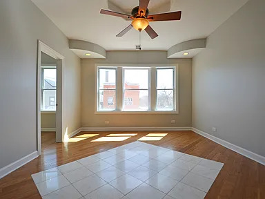 1922 West 47th Street, Unit 2 Chicago, IL 60609 - Photo 2 of 20 an empty room with chandelier fan and windows