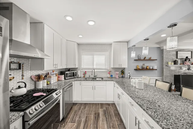 a large kitchen with stainless steel appliances granite countertop a stove and a sink