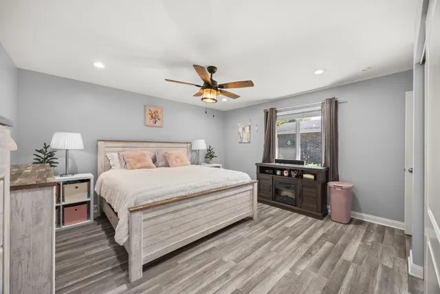a bedroom with a bed and wooden floor