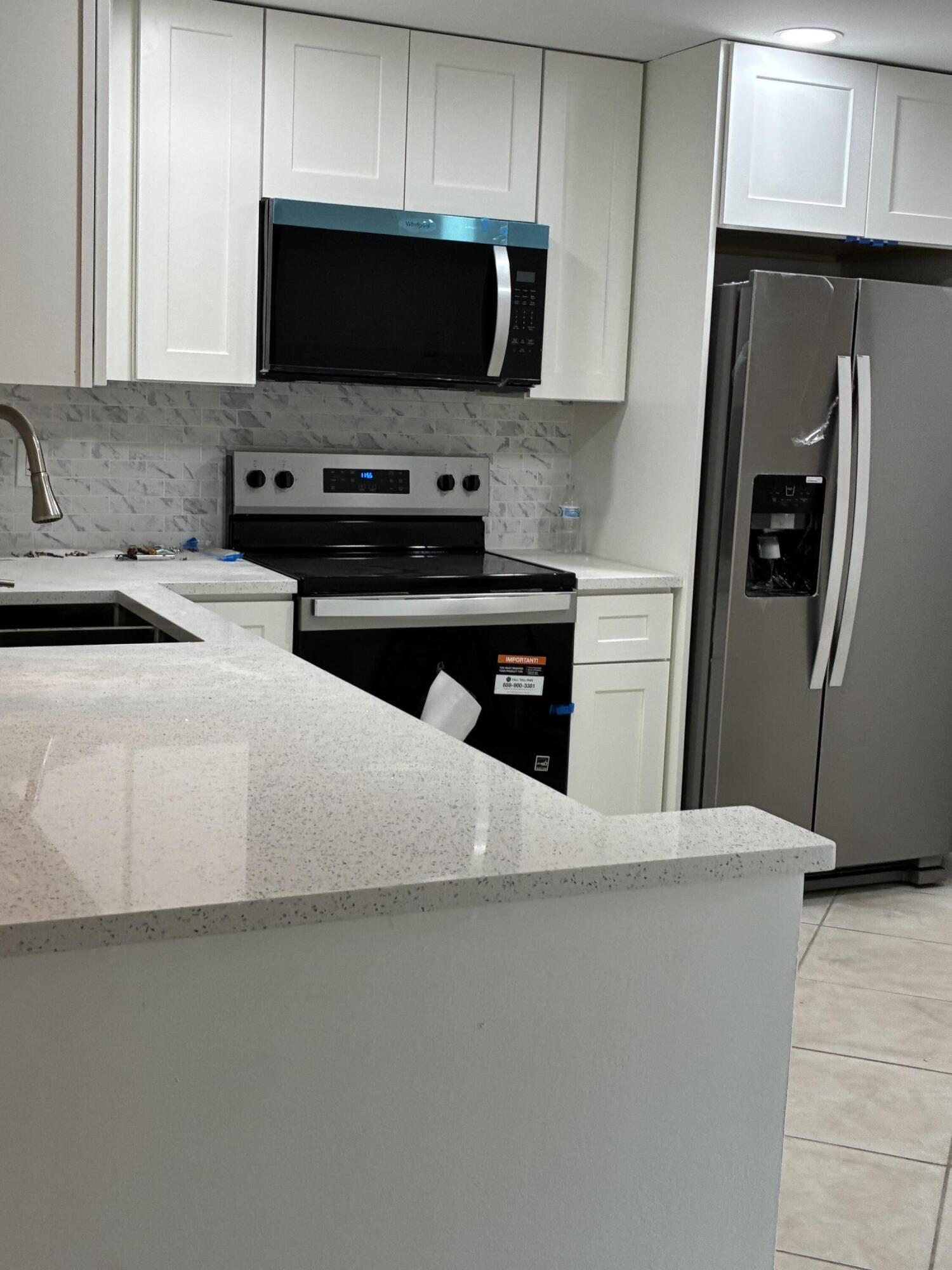 a kitchen with stainless steel appliances a stove a microwave and a sink
