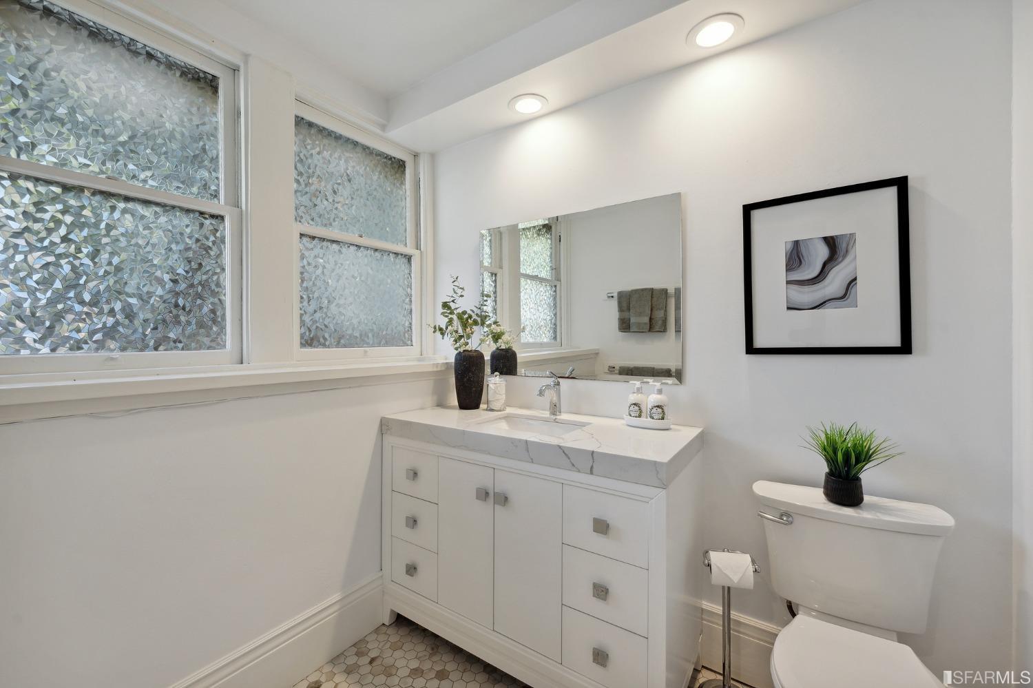 445 Clipper Street San Francisco, CA 94114 - Photo 54 of 62 a spacious bathroom with a toilet a sink and a mirror