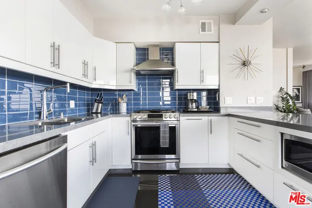 a kitchen with stainless steel appliances granite countertop a stove a refrigerator and a sink