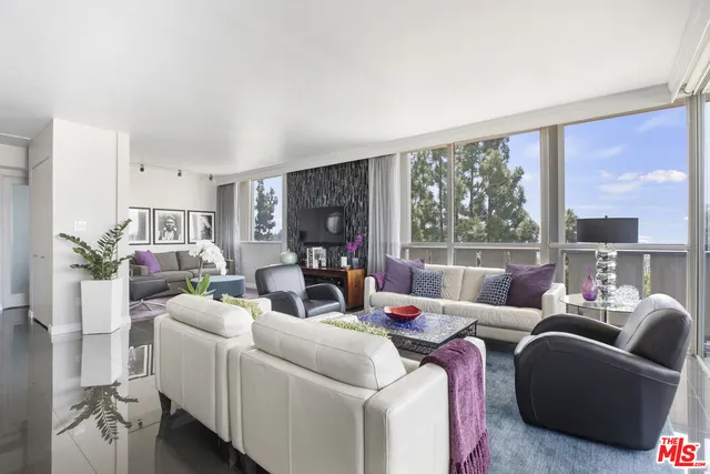 a living room with furniture fireplace and a large window