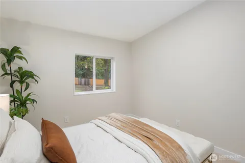 a bedroom with a bed and a potted plant