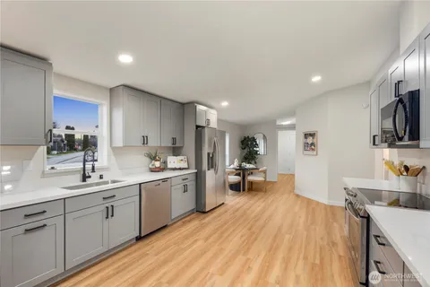 a large kitchen with a lot of counter space and wooden floor