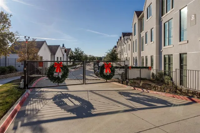 a view of a white house with a small yard and large tree
