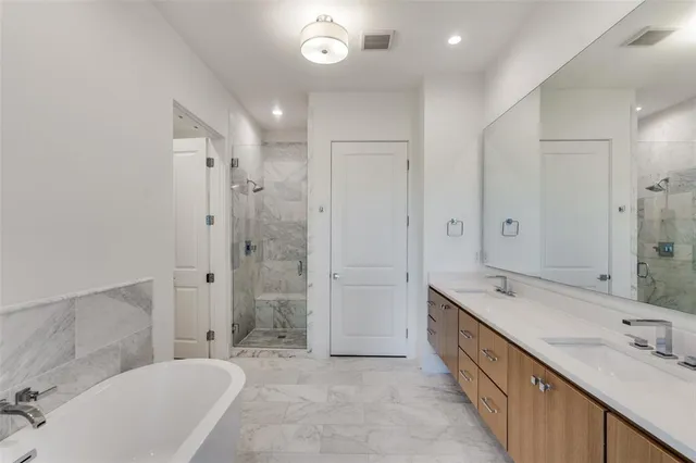 a spacious bathroom with a granite countertop sink mirror and bathtub