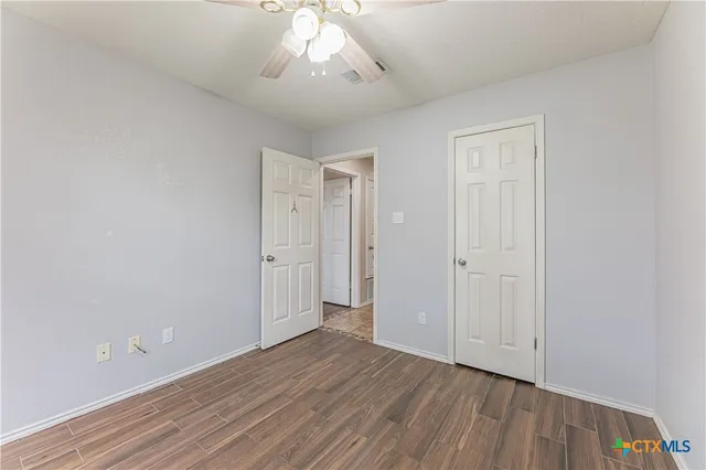 a view of an empty room with wooden floor