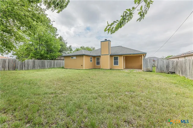 a front view of house with yard and trees in the background
