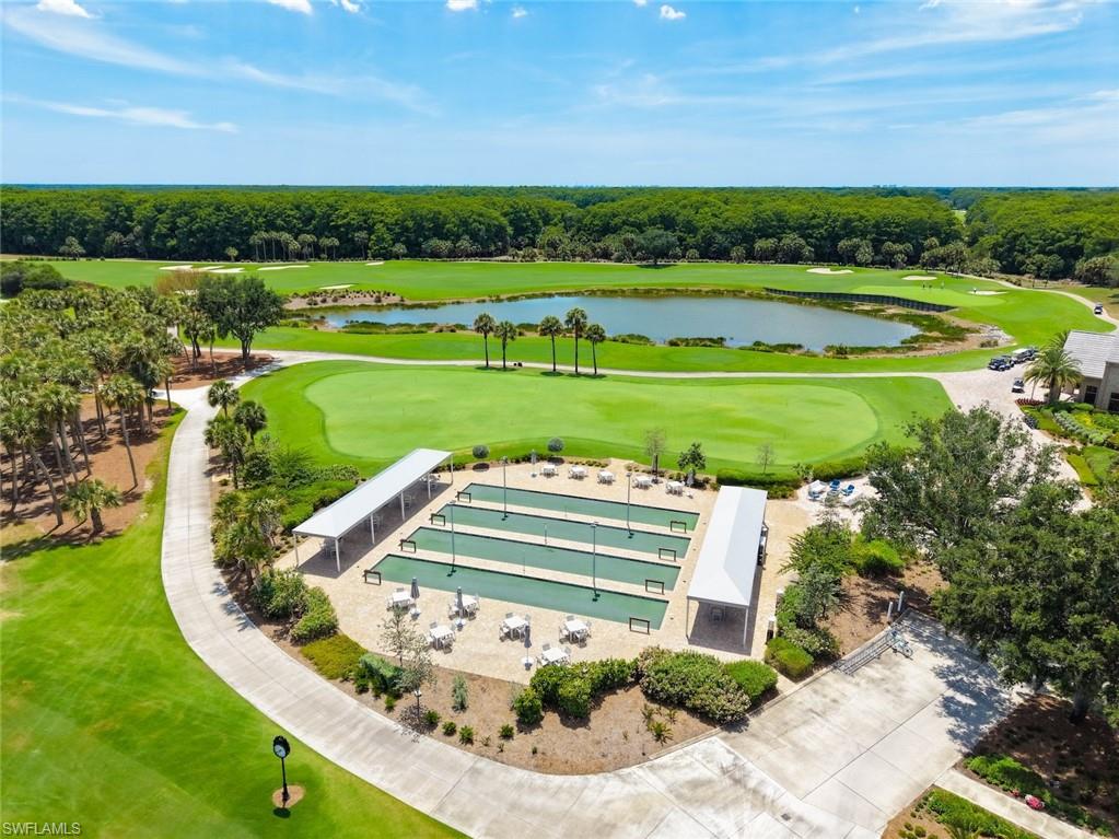 12692 Kinross Lane Naples, FL 34120 - Photo 36 of 47 Twin Eagles Bocce ball courts with shaded seating, expansive golf course, large pond, lush landscaping, and paved pathways