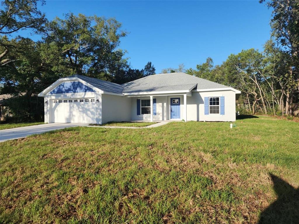 1111 Dagmar Avenue Spring Hill, FL 34606 - Photo 23 of 27 a front view of a house with a garden