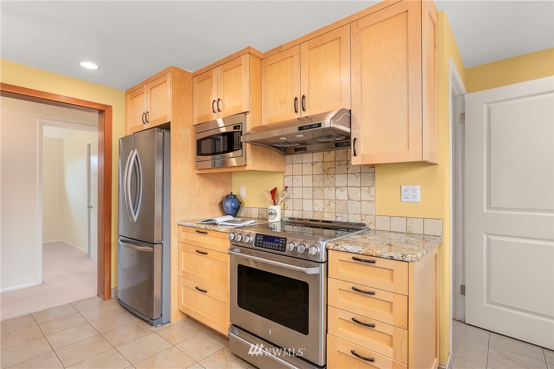 7139 South Sunnycrest Road Seattle, WA 98178 - Photo 11 of 28 a kitchen with stainless steel appliances granite countertop a stove a refrigerator and a refrigerator