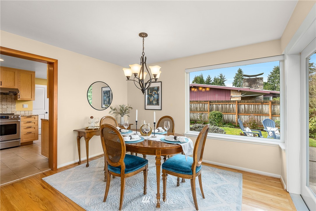 7139 South Sunnycrest Road Seattle, WA 98178 - Photo 7 of 28 a dining room with furniture a rug a potted plant and a chandelier