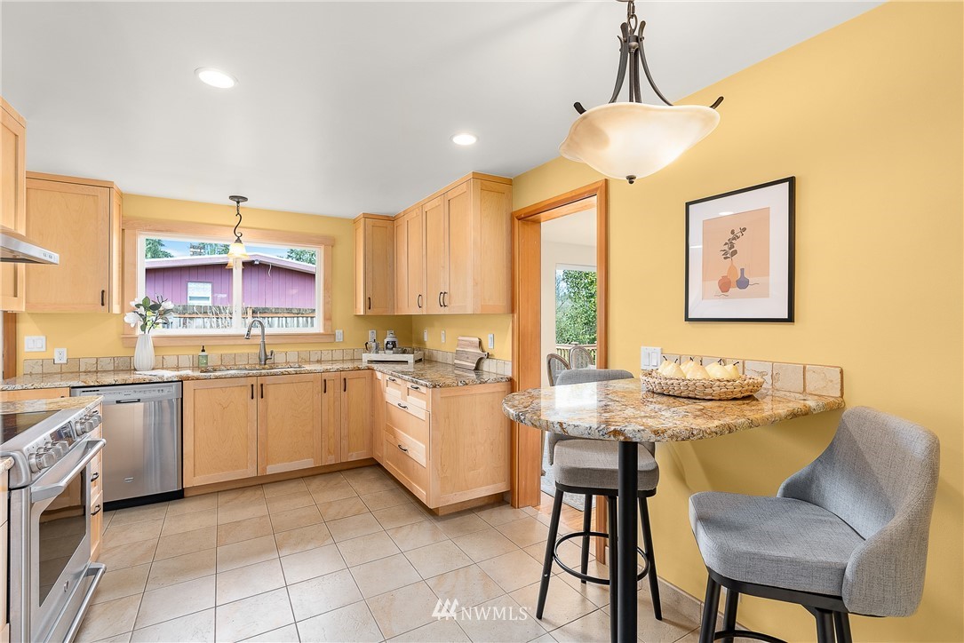 7139 South Sunnycrest Road Seattle, WA 98178 - Photo 10 of 28 a kitchen with a stove a sink a counter top space and living room view